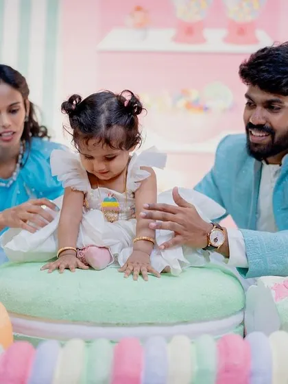 A playful moment with the family at the Candyland party, featuring giant macaron props.