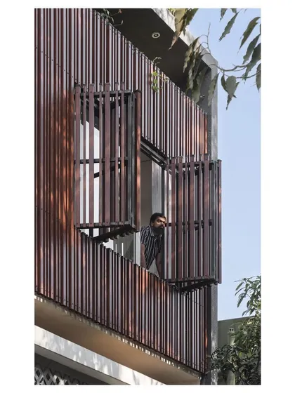 The upper floor features operable shutters made from the same vertical fins as the facade screen. This allows residents to control the amount of light and air, and to connect with the street below.