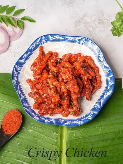 A simple yet satisfying starter of Crispy Chicken, perfectly fried and seasoned. It's served on a traditional banana leaf, which adds a subtle aroma, alongside a spicy dipping sauce.