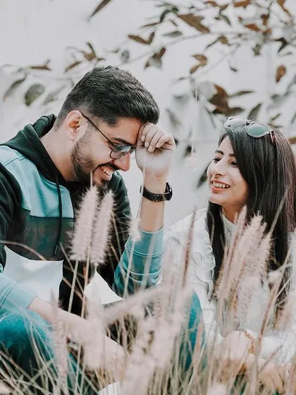 Capturing the simple, happy moments is what I do best. This candid pre-wedding photo shows the couple sharing a lighthearted laugh, framed by soft pampas grass for a natural, relaxed feel.