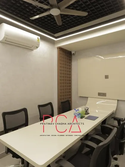 A smaller meeting room or cabin within the StyleIn Homes office, featuring a clean, minimalist design with a whiteboard and functional furniture.