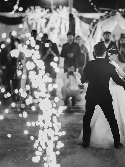 The couple's first dance surrounded by cold pyro sparklers. This black and white image is dramatic and full of celebratory energy.