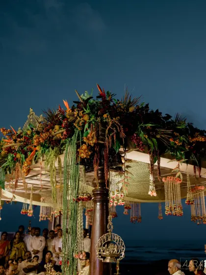 The wedding mandap at dusk, with the Bay of Bengal as its infinite background. The design combines traditional pillars with a canopy of tropical flowers, creating a truly magical setting for the ceremony.