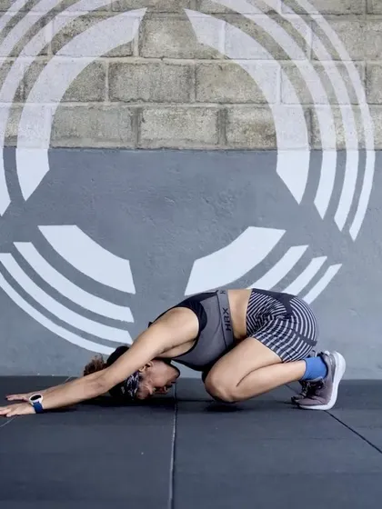 A member in the Child's Pose, a key resting posture in Animal Flow.