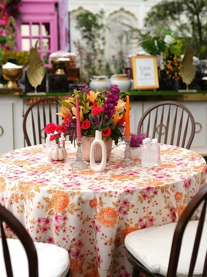 A beautiful floral table centerpiece with a printed tablecloth. The combination of fresh flowers and elegant linens elevates the dining experience for guests.