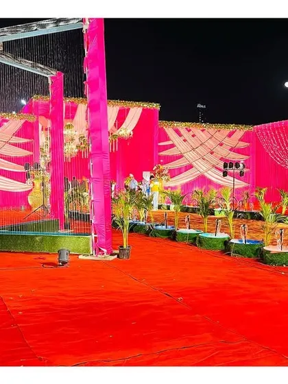 A wide shot of the pink-themed outdoor venue, showing the scale of the decoration and the inclusion of rain-cover structures for practicality.