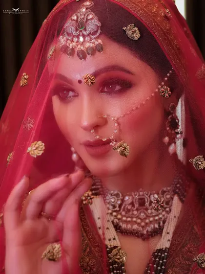 A creative shot through a red veil, creating a soft, dreamy filter. This technique adds a layer of romance and mystery to the bridal portrait.