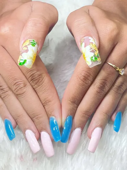 A creative and colorful set combining solid colors with floral nail art. This demonstrates the versatility our students gain in their design skills.