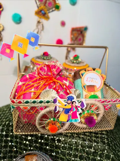 This elegant golden wire basket is perfect for a sophisticated Lohri gift. It's decorated with Punjabi folk art motifs and filled with beautifully packaged treats.