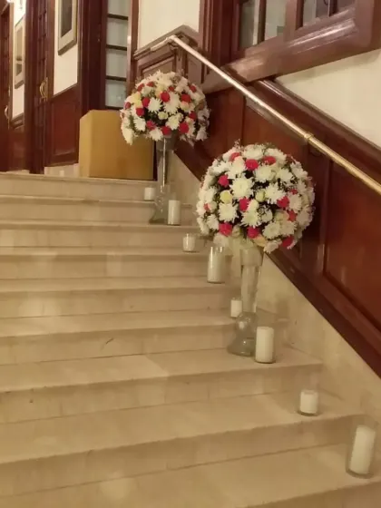 Simple yet effective decor for a staircase. Large spherical flower arrangements and scattered candles transform a functional space into a beautiful part of the event decor.