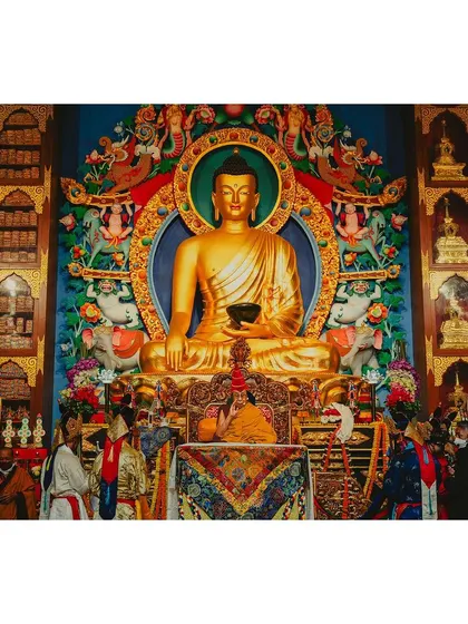 A wide view of the main shrine during a teaching by the Dalai Lama, showing the ornate altar and the golden Buddha statue. This photograph documents the scale and grandeur of the spiritual ceremony.