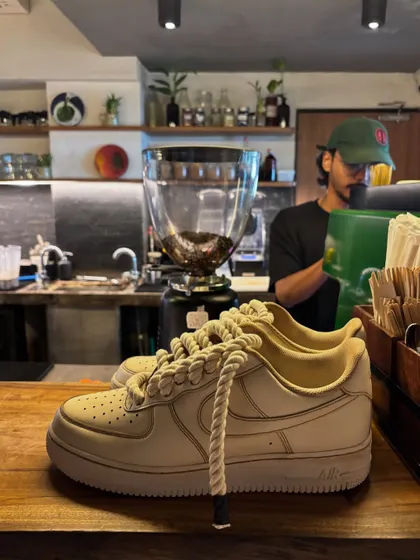 Another shot of the coffee custom sneakers in a cafe setting.