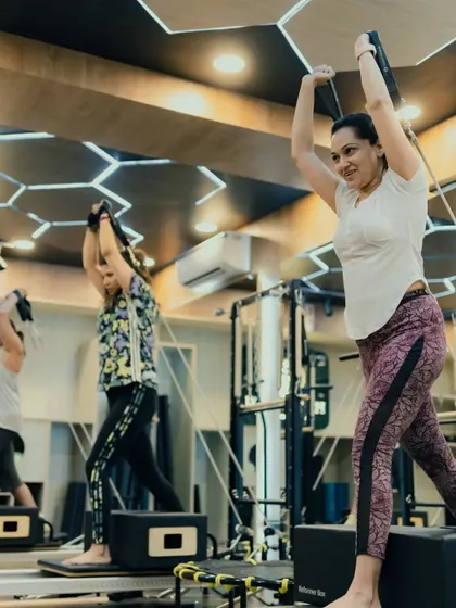 This exercise combines a lunge with an upper body press, creating a full-body movement that enhances coordination and strength. The class looks focused and powerful.