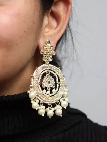 A few pearls entangled in a way that is sharper than my outfit, but not than my confidence. A model wears our kundan and pearl chandbali hoops, a perfect blend of modern and traditional.