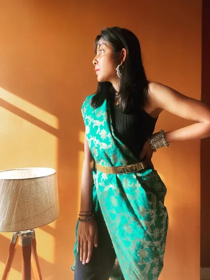 A creative way to style a saree or dupatta. Here, I've draped a green Banarasi dupatta over a black top and pants, using a belt to cinch the waist and create a modern, pant-saree look.