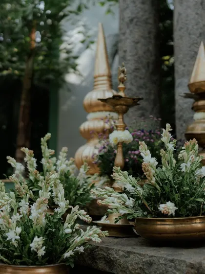 A decor detail combining traditional brass elements with fresh white tuberoses.