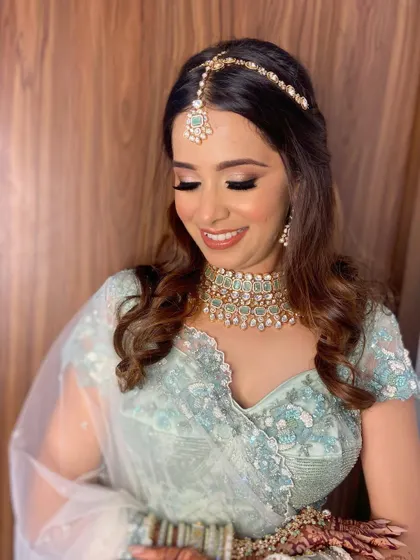 The complete look, from the soft curls to the delicate maang tikka. Aashna's makeup ties everything together for a cohesive and elegant bridal style.