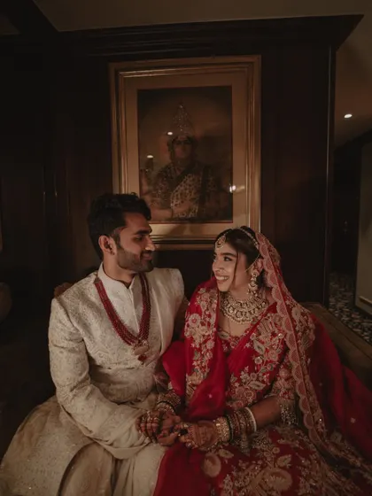 A candid moment of conversation and smiles between the bride and groom during their wedding portraits.
