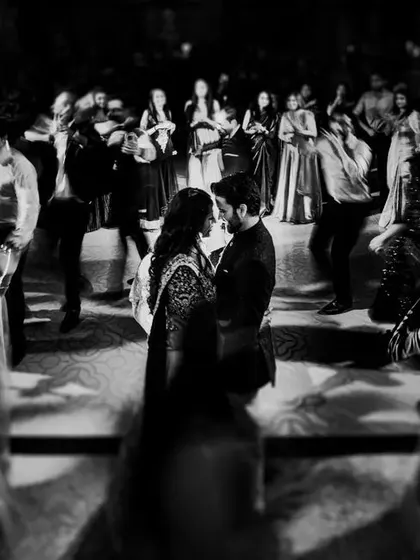 A beautiful black and white photo where the couple shares a quiet moment in the middle of a busy dance floor. This shot feels like time has stood still just for them.