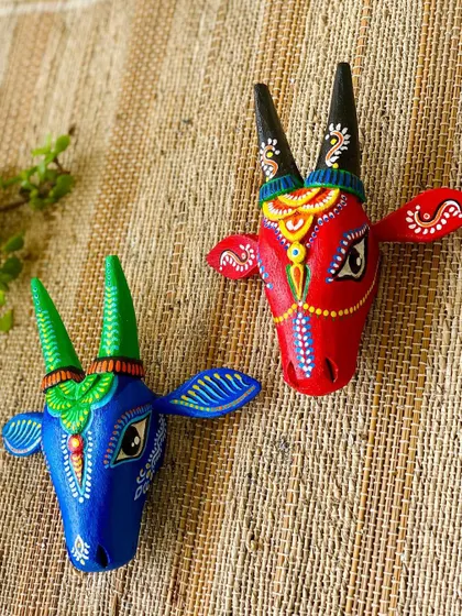 A pair of Nandi heads in bright blue and red. They are designed as a complementary set, perfect for creating a balanced and colorful wall display.
