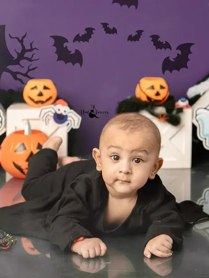 A curious baby dressed as a bat explores the Halloween themed set.