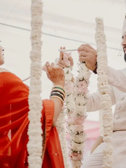 The bride and groom exchange garlands during the Varmala ceremony, a key ritual in their wedding.