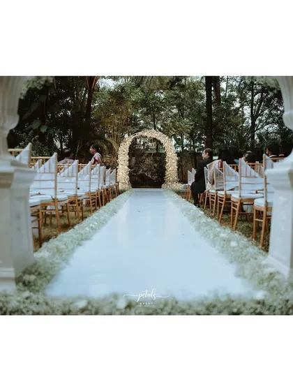 Another perspective of the dreamy Christian wedding setup, with the floral arch and Victorian vases creating a picture-perfect scene.