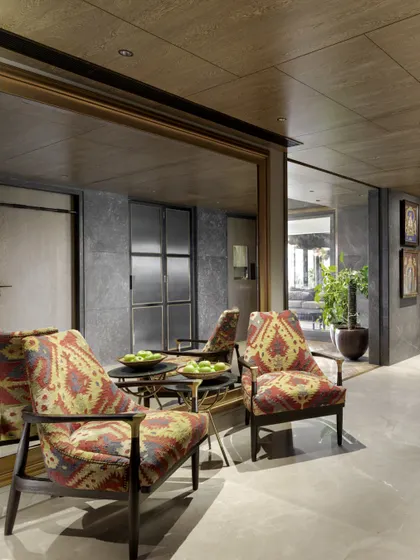 Another view of the Caitriona apartment entrance, where the large gilded mirror reflects the 'Arizona Armchairs', expanding the space and adding a touch of glamour.