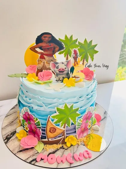 A tropical Moana-themed cake with ocean waves, palm trees, and the adventurous princess herself.