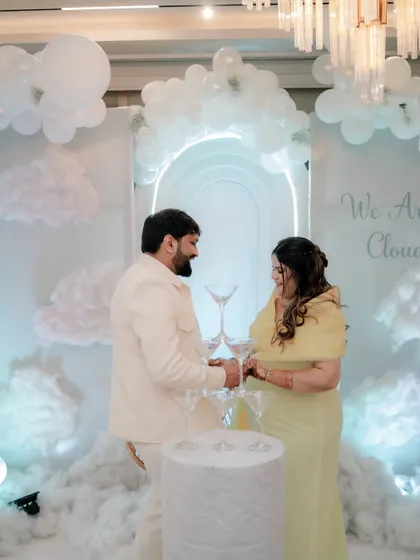 The couple shares a toast with a champagne tower, a chic and celebratory element for a modern baby shower.
