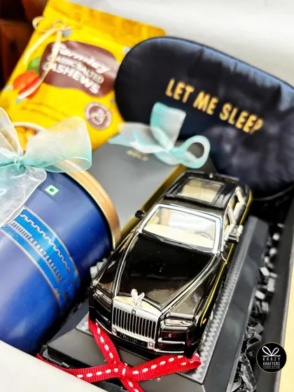 A luxury-themed hamper for the man who loves his cars. This gift includes a Rolls Royce miniature, a 'Let me sleep' eye mask, and premium snacks.