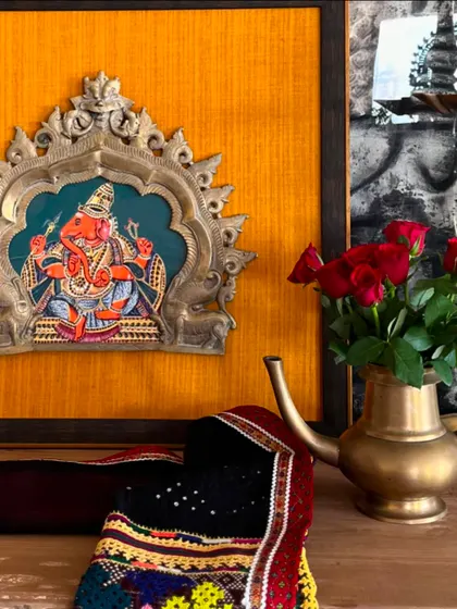 A detail shot of the Ganesha Prabhavali, showing the rich texture of the yellow fabric and the intricate details of the vintage brass halo. It's a perfect blend of old and new.