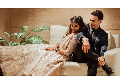 A relaxed, lifestyle portrait of the couple sharing a quiet moment on a sofa. These casual shots are a wonderful way to capture your connection in a comfortable setting.