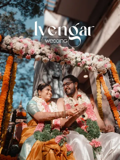 A joyful moment from an Iyengar wedding, with the couple on a decorated swing, surrounded by flowers.
