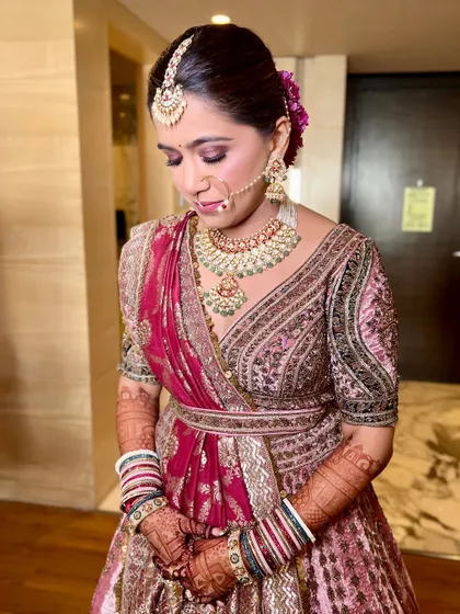 A close-up of the bride looking down, showcasing her soft smokey eye and the intricate details of her outfit.