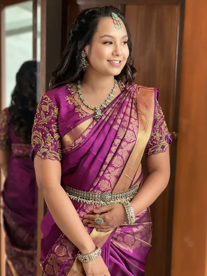 A dewy, minimal look for this bride in a royal purple silk saree. Her natural glow is enhanced, and her soft, loose waves complete this beautiful, modern-traditional transformation.