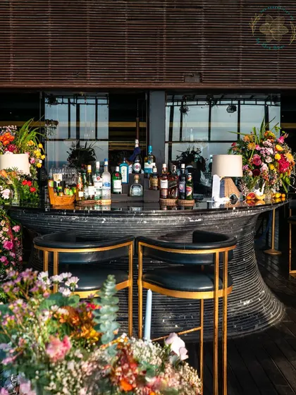 A beautifully styled bar for a sundowner party, surrounded by lush floral arrangements. The bar is often a central point of a party, so we make sure it looks spectacular.