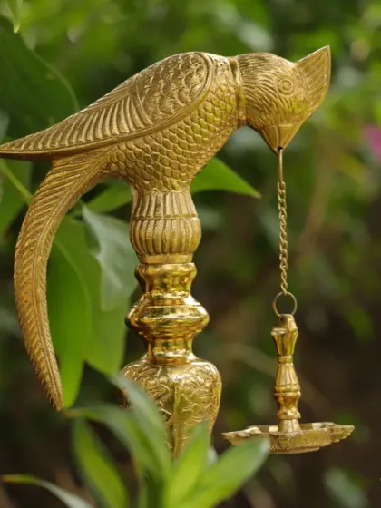 A traditional brass parrot lamp (kuthu vilakku), a beautiful and symbolic piece of decor that connects to South Indian heritage.