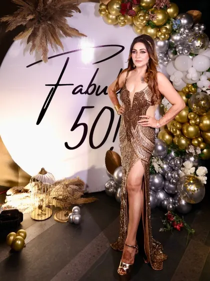 Fifty and fabulous in every golden sparkle. The birthday queen poses against the custom backdrop we created, which perfectly complements her stunning sequined gown.
