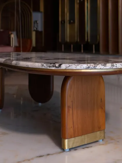 This classic coffee table, with its unique marble top and sculptural wooden base, was custom-designed to complete the living room decor. It perfectly balances form and function.