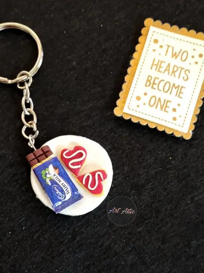 For the chocolate lover! This cute keychain features a miniature Dairy Milk bar and heart-shaped cookies, all sculpted from clay.