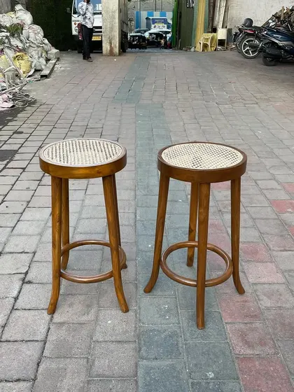 A pair of classic bar stools with hand-woven cane seats and elegantly curved legs. Made from solid teak, these stools are lightweight yet extremely durable for cafe or bar use.