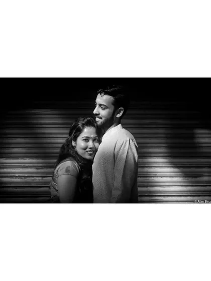 A powerful black and white anniversary portrait. The dramatic lighting and close embrace create a feeling of intimacy and enduring love.