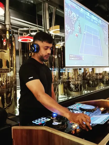 Even at a brewery or sports bar, I can integrate visuals. Here, I'm mixing music while a live tennis match plays on the projector, showing how I can adapt my VJ services to any context.