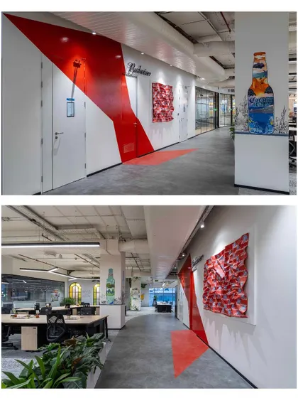 A closer look at the AbInbev hallway. The Budweiser bow is painted directly onto the wall, and a column features a sustainability-themed piece. The red fabric sculpture by artist Nilesh was commissioned to add texture and dimension.