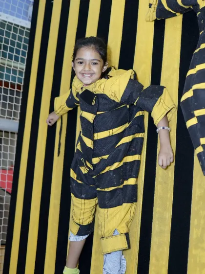 The pure joy of play is evident on this young guest's face as she hangs out on our velcro wall. We design our activities to be engaging and exciting for every child.