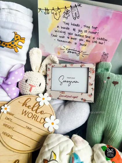 This pastel-themed newborn hamper includes a frame to insert the baby's sonogram, making it a truly personal and sentimental gift.