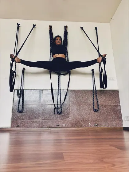 This close-up shows the full extension in the supported Center Splits. Using props like the yoga wall makes advanced flexibility training safer and more effective, enabling gradual progress.