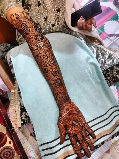 A single-arm view of a full bridal design. This perspective highlights the flow of the pattern from the hand up the arm.