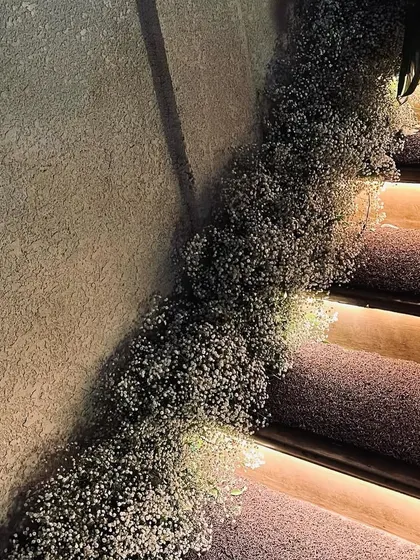 We believe in transforming every part of a venue. Here, we adorned the staircase with cascading baby's breath, creating a soft, dreamy pathway that enhanced the event's romantic theme.